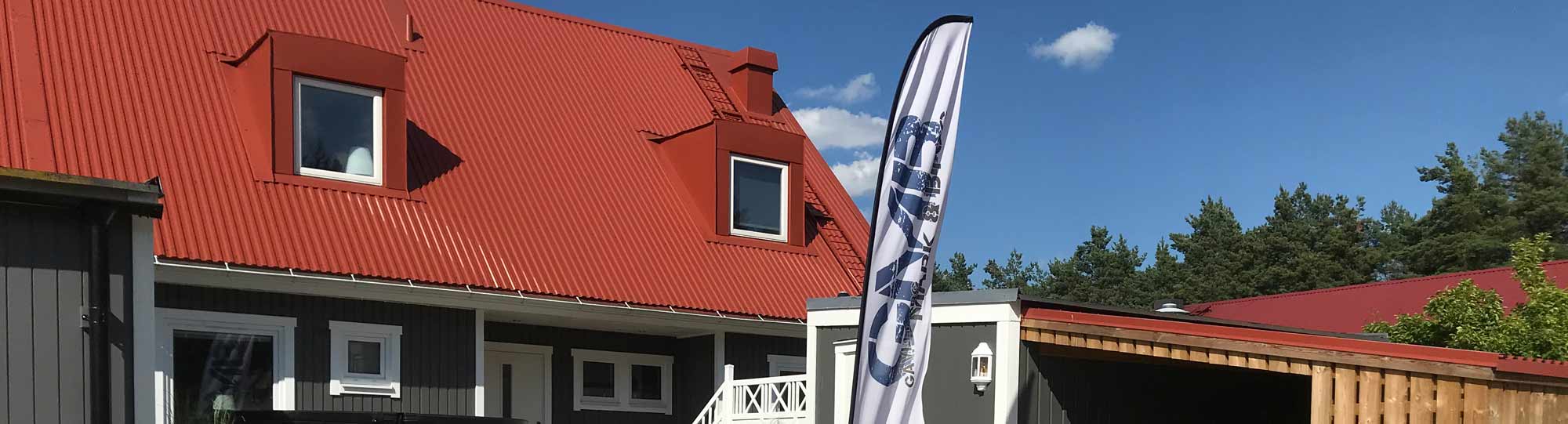 En flagga med texten Gävleborg mark och bygg som står framför ett hus